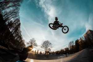 person riding bike while in mid air in skate par