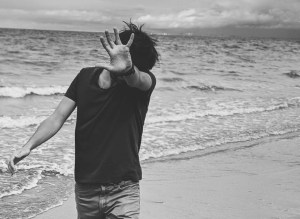 monochrome photo of person standing on seashore
